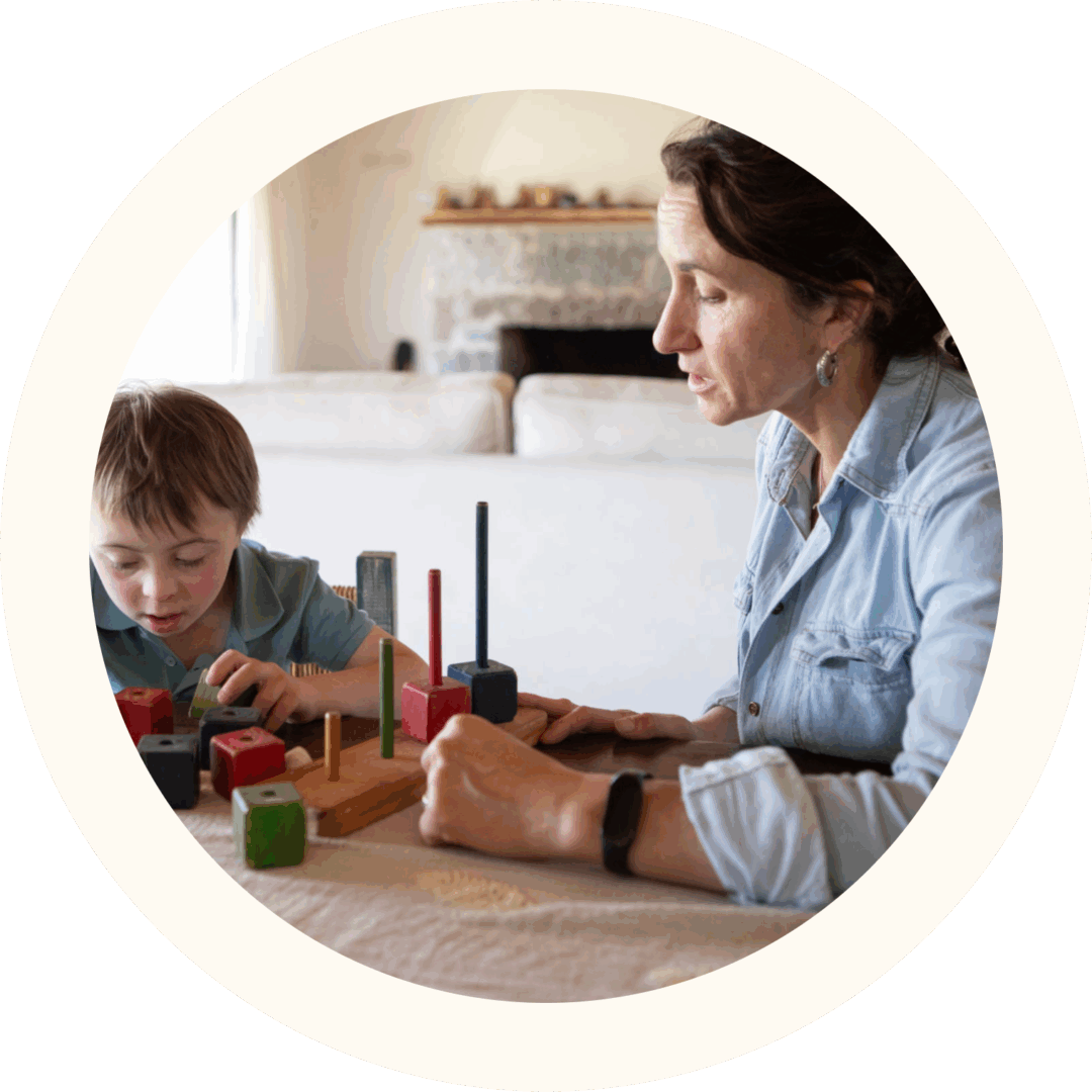 Woman and boy playing with wooden blocks.